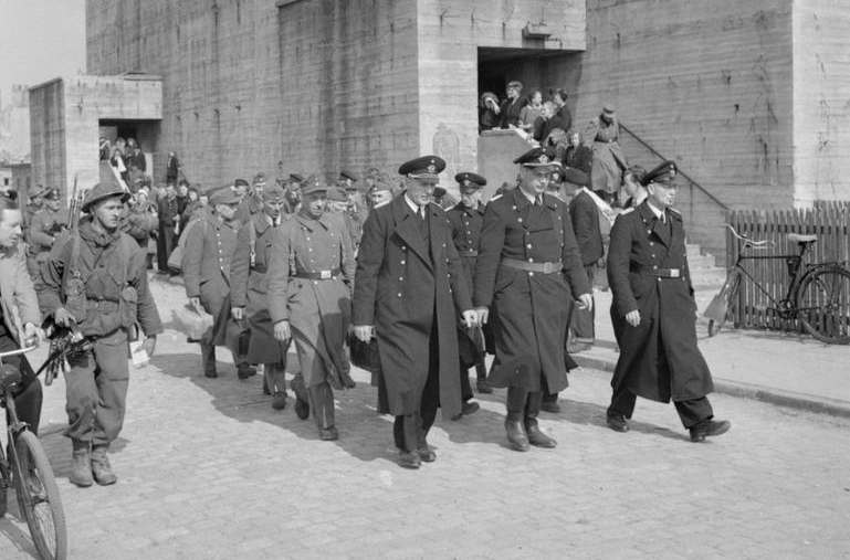 Deutsche Soldaten werden in Gefangenschaft geführt