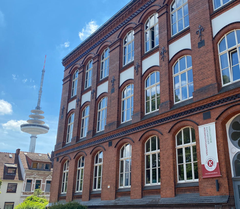 Foto mit der Fassade des Kulturhauses und dem Fernsehenturm in Walle. Das Gebäude ist sehr alt und aus roten Klinkern.