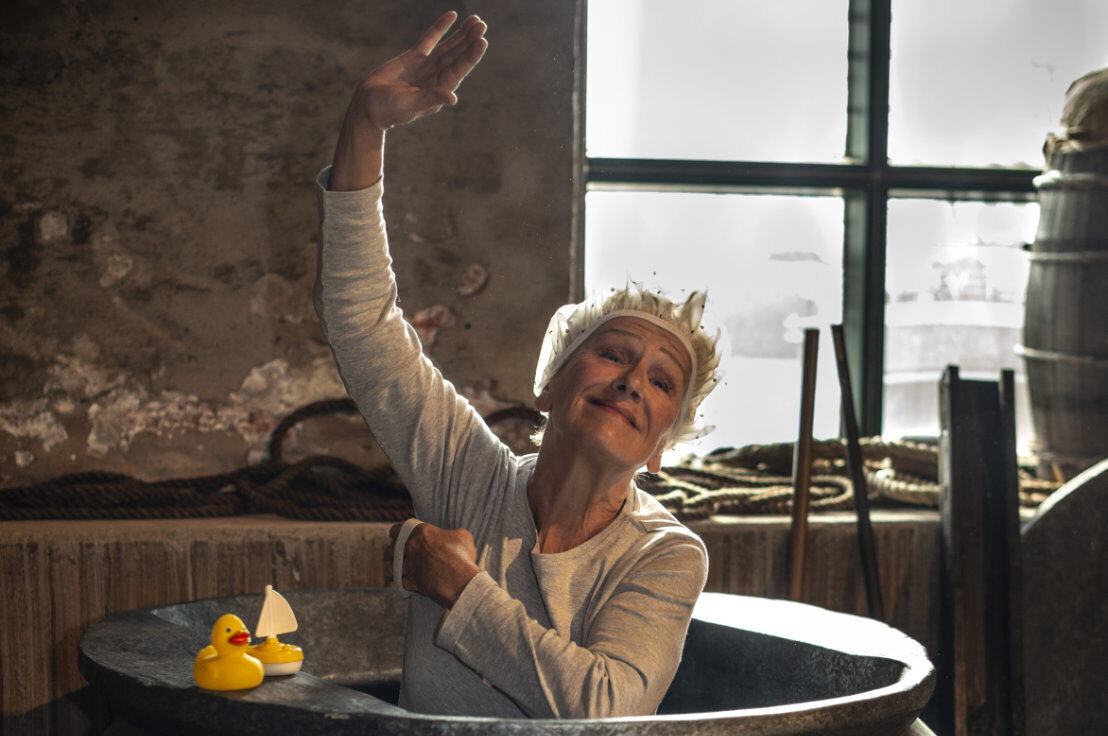 Foto von Schauspielerin in einer alten Badewanne aus Eisen mit Ente uns Schiff