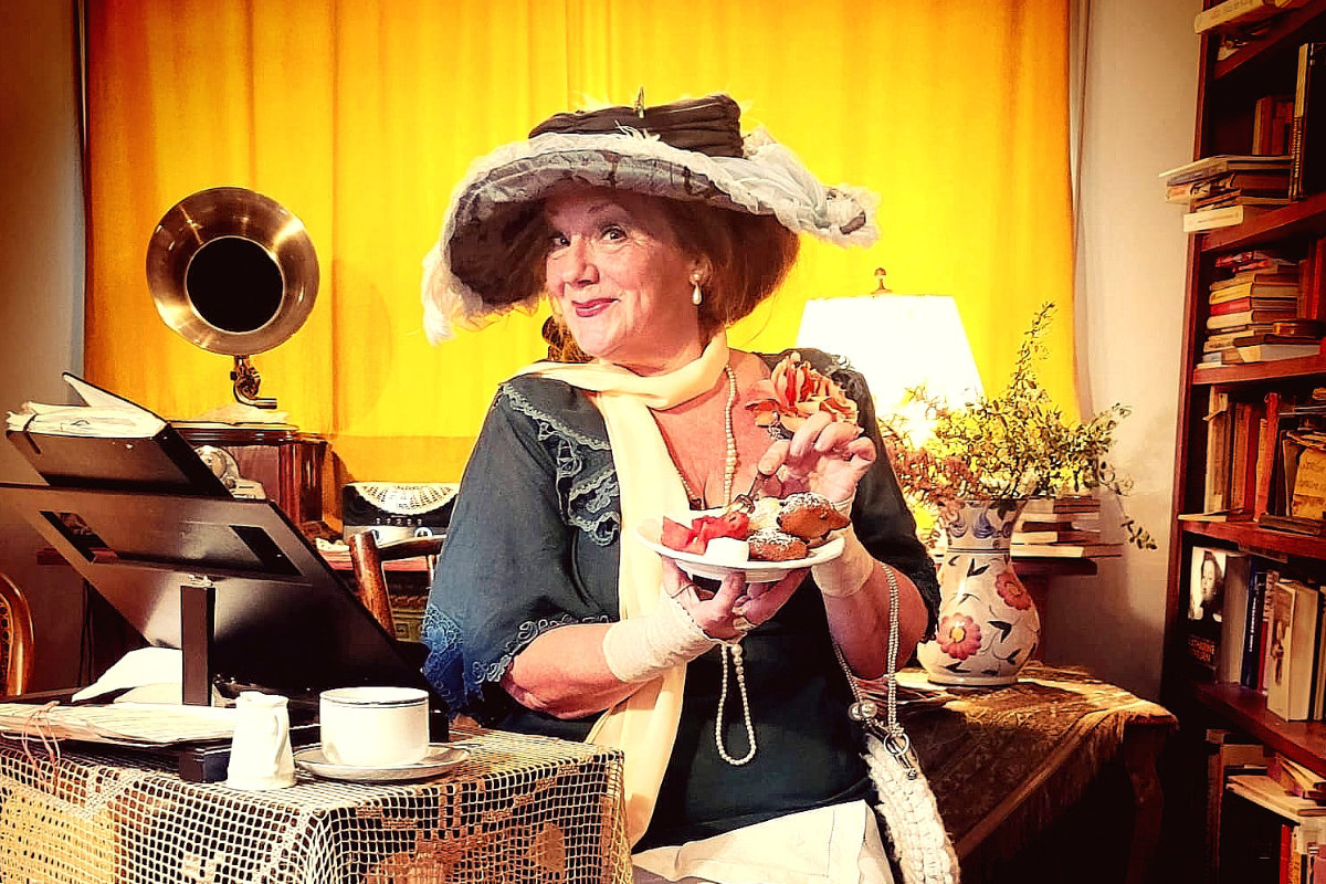 Foto, Madame B im historischen Kostüm hält alte Teetasse und lächelt mit einem Gramophon im Hintergrund