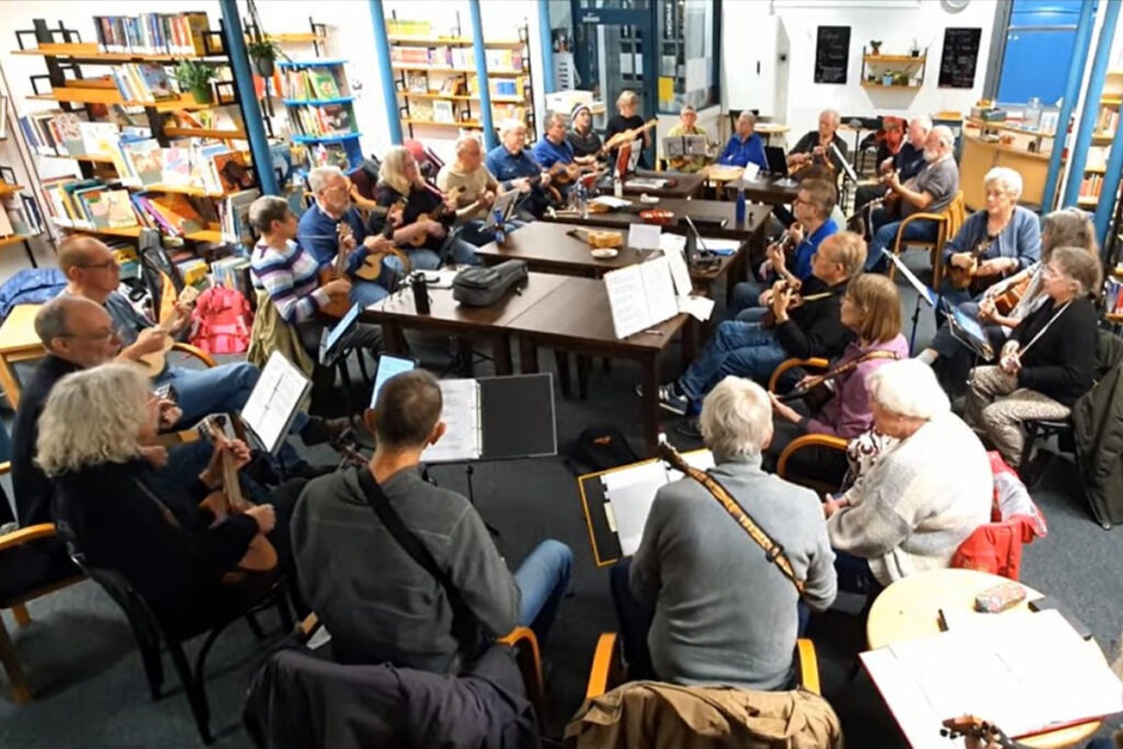 Menschen spielen Ukulele in großer Runde